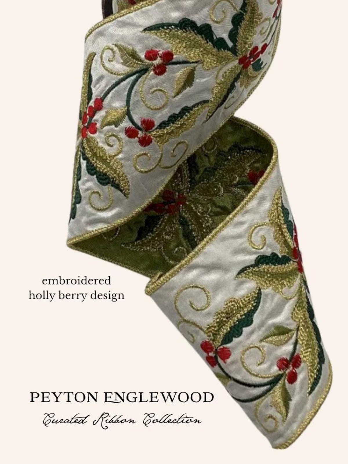 An embroidered ribbon with a holly and berry design, shown in a spiral fold on a light cream background. The ribbon features green leaves, red berries, and gold embroidery on a white satin base.