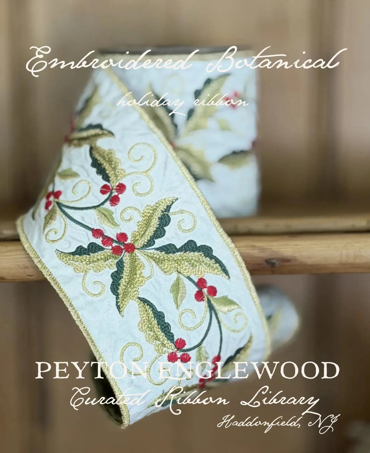 An embroidered holiday ribbon with botanical motifs, featuring green leaves, red berries, and gold scrollwork on a white background, draped over a wooden surface. Text overlays read 'Embroidered Botanical holiday ribbon' and 'PEYTON EGGLEWOOD Curated Ribbon Library'.